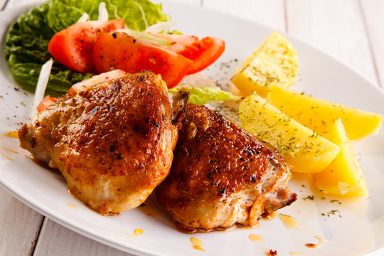 Grilled chicken thighs with boiled potatoes and vegetable salad 