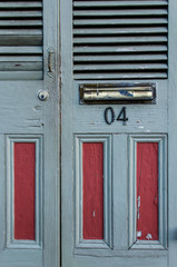 Slate grey and burgundy red door with number on it and mail slot