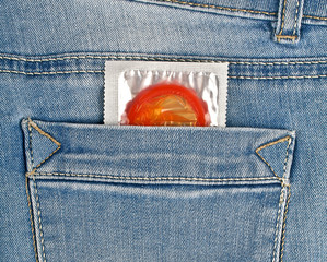 Red condom in blue jeans pocket