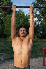 Happy, young, good looking guy exercising in nature