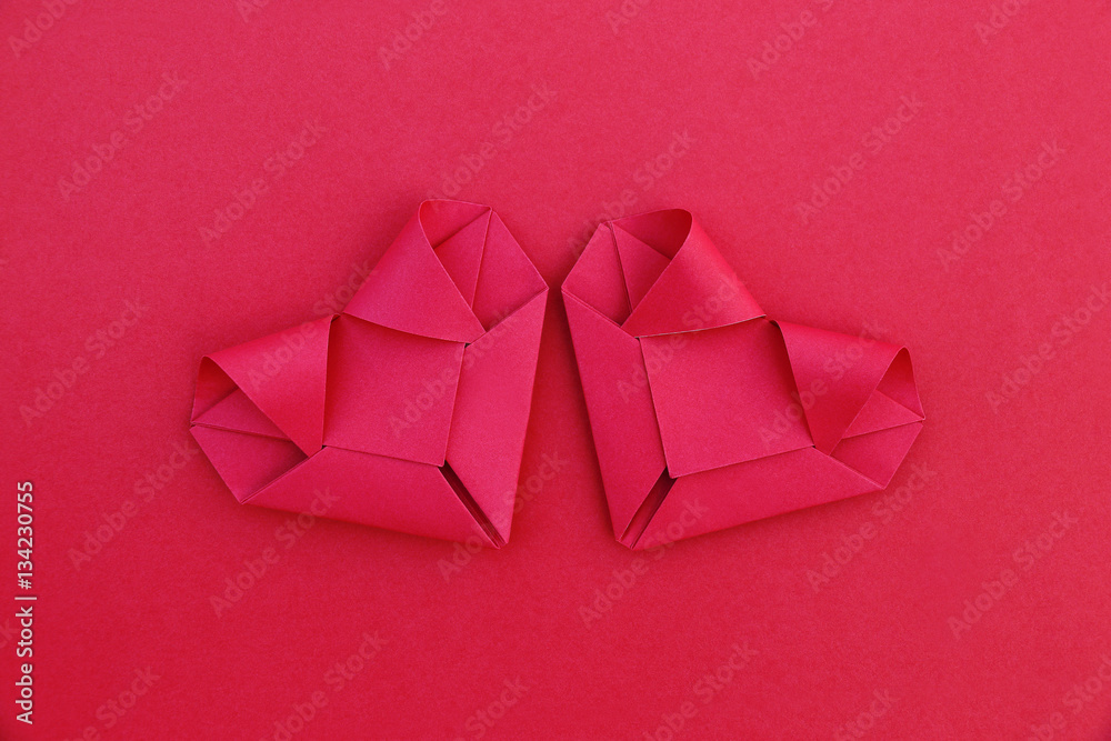 Poster two folding red paper hearts on red for pattern and background