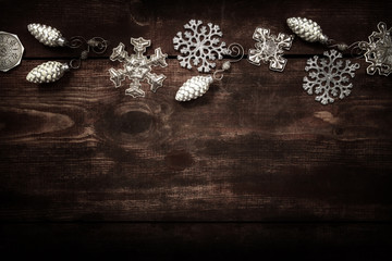 Silver snowflake Christmas ornament border on a wooden backgroun