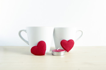 Red heart shape with two white mugs on wood table. concept for v