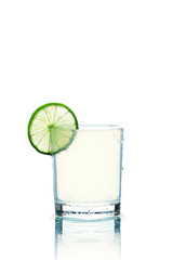 Glass of transparent beverage and lime slice