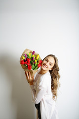 Woman is happy with a bouquet of colored tulips, a gift on 8 Mar