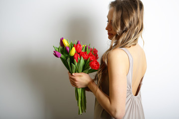 Young woman holding a bright tulips. Concept: gift on 8 March