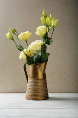 Romantic flowers in ancient pitcher on wood