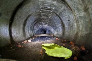 Flooded round sewer tunnel with dirty water and mud 