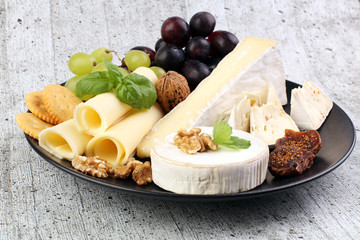 Cheese platter with different cheese and grapes and red wine