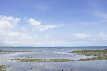 mini fishing boat on the beach with sand sea and bright sky and cloud on sunshine day for holiday of the people, soft light background.