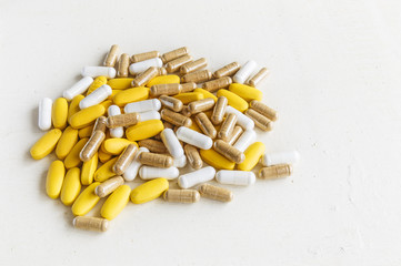 Vitamin pills lying on a wooden board painted