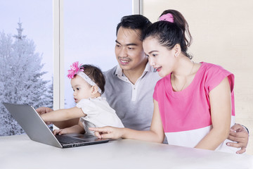 Daughter and parents looking at laptop