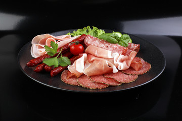 Food tray with delicious salami, pieces of sliced ham, sausage,