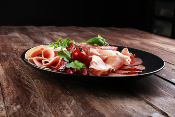Food tray with delicious salami, pieces of sliced ham, sausage,