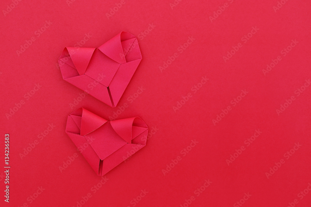 Poster two folding red paper hearts on red for pattern and background