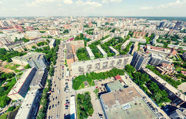 Fototapeta premium Aerial city view with crossroads and roads, houses, buildings, parks and parking lots, bridges. Urban landscape. Copter shot. Panoramic image.