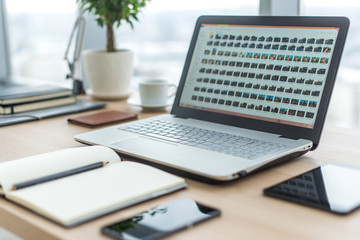 Sideview of office desktop with blank laptop and various tools.