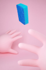 A funny interpretation of cleaning with pink rubber gloves and flying blue sponge