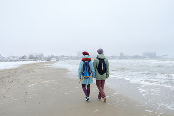 young couple walking on a winter beach. Rear view
