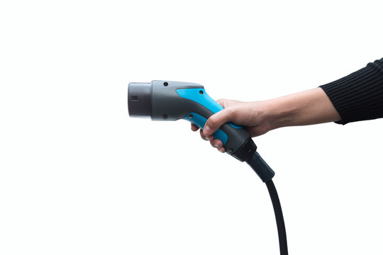 Hand Holding Electric Car Charger On White Background. Air Pollution And Reduce Greenhouse Gas Emissions Concept.