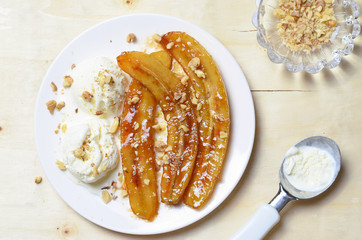 Caramelized Bananas, Ice-cream and Chopped Nuts Dessert on a plate