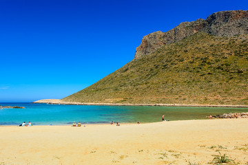 Tourists relax and bath on the Stavros beach, made famous by Anthony Quinn the film Zorba the Greek. Crete island, Greece. 