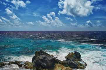 White waves of the blue sea breaking on the rocks