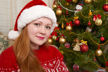 Beautiful girl in christmas decoration. Home interior with decorated fir tree and gifts. New year eve and winter holiday concept.
