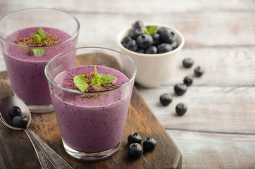 Blueberry and banana smoothie with oatmeal on the rustic wooden table, selective focus, horizontal, copy space