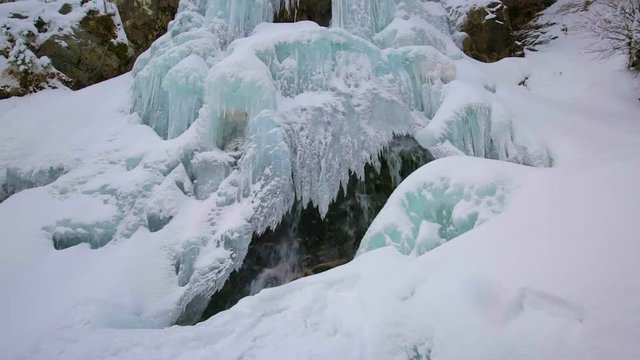 Panning fottage of a waterfall in the winter with icicles