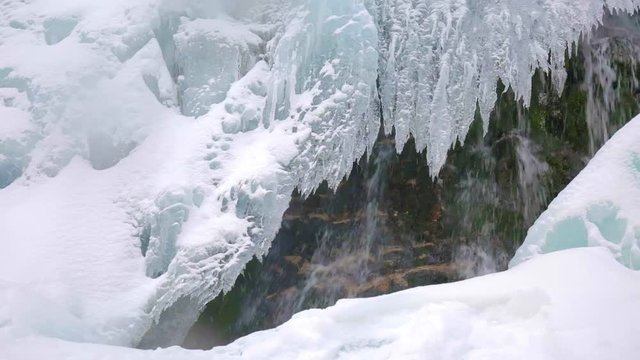 Sliding fottage of a waterfall in the winter with icicles