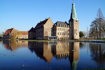 Fototapeta premium Schloss Raesfeld mit Spiegelung im zugefrorenen Wassergraben.