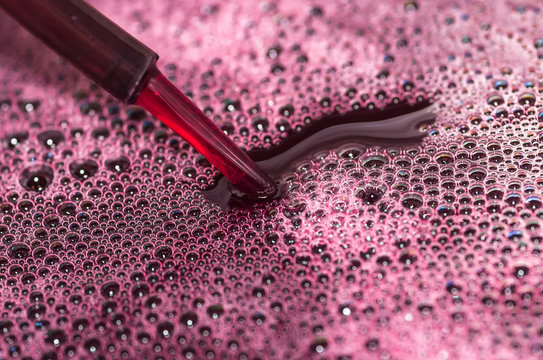 Bubbles of red wine closeup. Alcoholic background