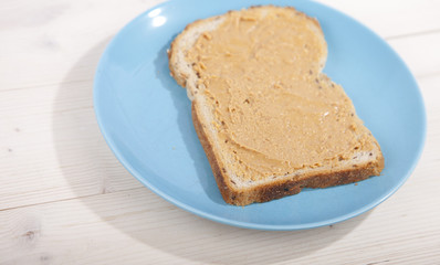 Bread with peanut butter on wooden background