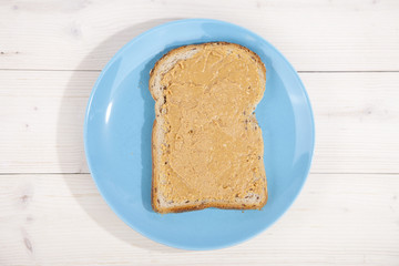 Bread with peanut butter on wooden background