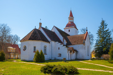 Fototapeta na wymiar Traditional local Estonian Lutheran church. White stone and red tile roof.
