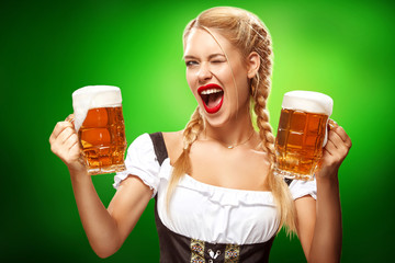 St Patricks Day. Young sexy Oktoberfest waitress, wearing a traditional Bavarian dress, serving big...