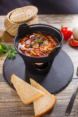 Hot goulash soup in a black pot