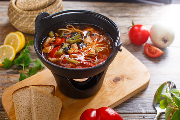 Hot goulash soup in a black pot