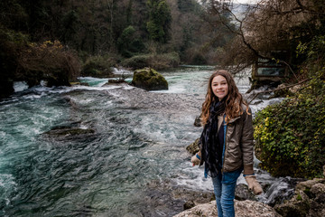 Naklejka premium Fillette au bord de la Sorgue vers le gouffre de Fontaine-de-Vaucluse