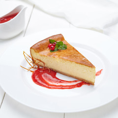 Slice cheesecake with strawberry sauce, berries and mint on white background isolated. Cheese cake New York on the white table.