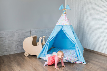 Child playing with a teepee tent