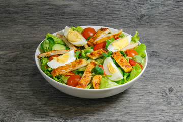 Grilled chicken salad with lettuce, tomatoes and eggs