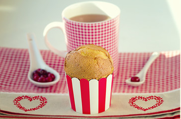Cupcake, cranberries and tea served in red and white checkered pattern with embroidered hearts
