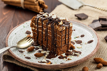 Slice of delicious chocolate Spartak cake on a rustic plate. First class dessert on a white wooden table.