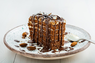 Piece of chocolate Spartak cake on a table. Delicious sweet food on a beautiful plate. Close-up shot.