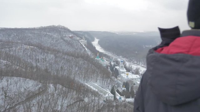 a Middle Aged Man Looking at Sviatogorskaya Lavra From the Observation Deck of the Monument to Artyom in Snowy Winter