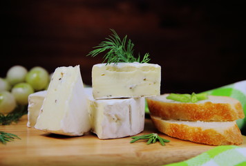 сыр камамбер с зеленью,виноградом и багетом на сервировочной доске
