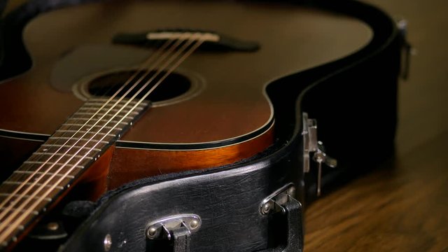 The man pulls out a guitar out of the case