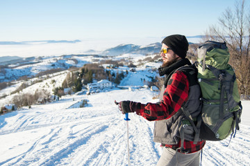 Fototapeta na wymiar Bearded backpacker standing on the mountain